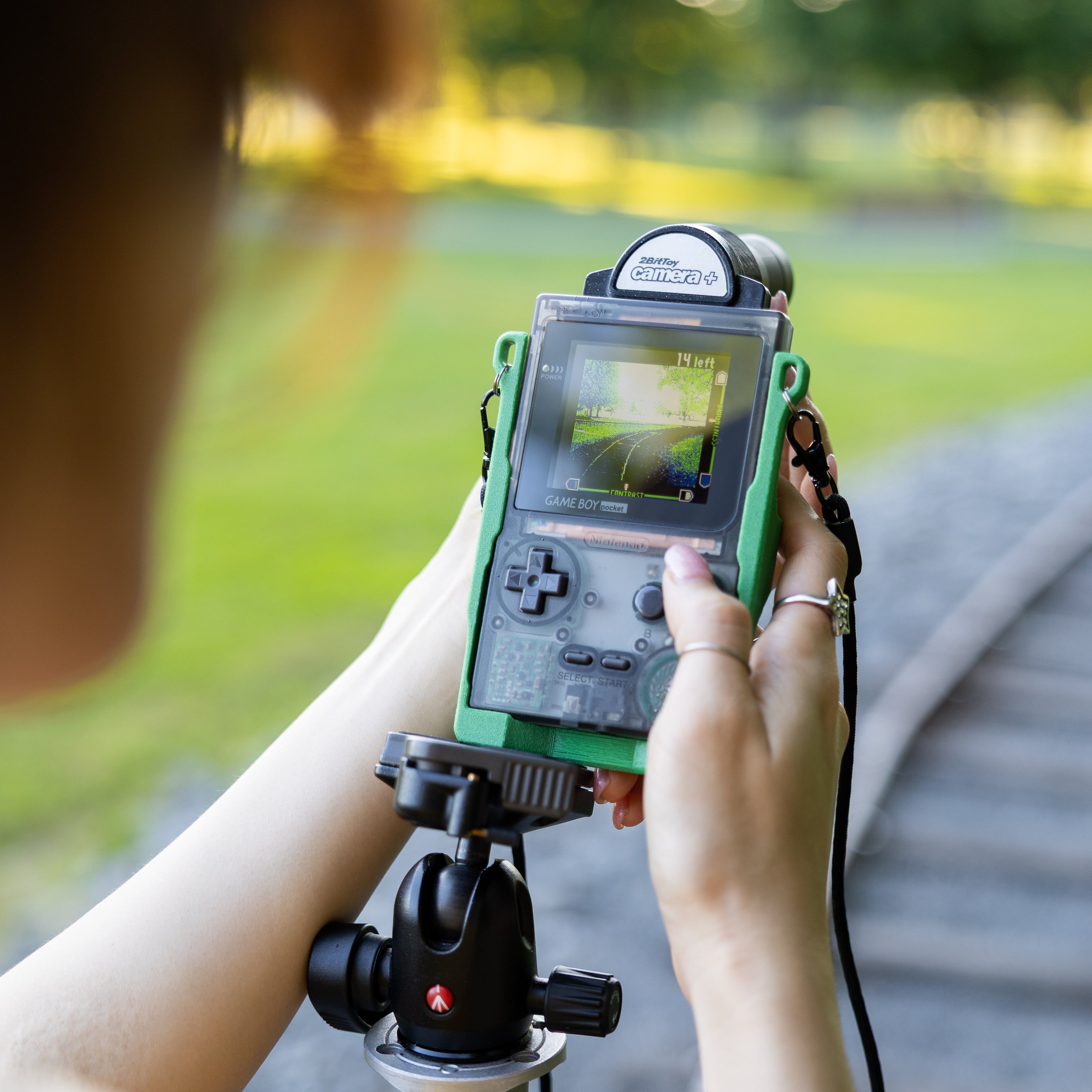  Detailed view of the dual tripod mount 3D-printed Game Boy Pocket carrier in use.
