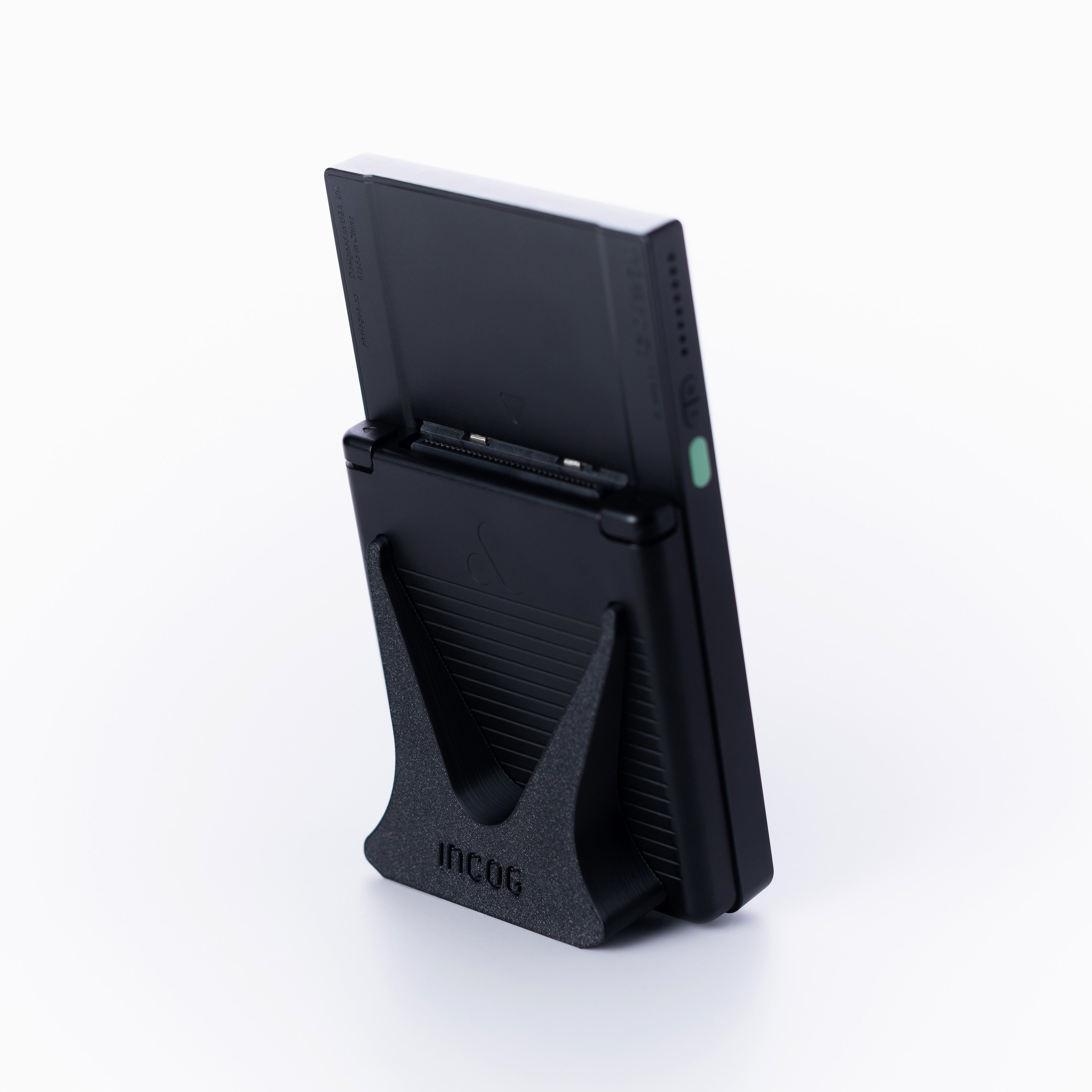 A black Analogue Pocket console using an INCOG display stand, against a clean off white background.