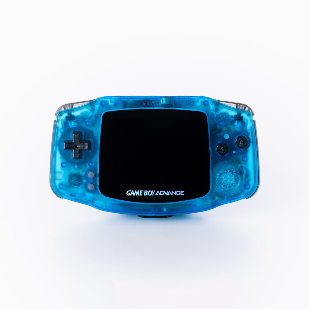A translucent blue Game Boy Advance handheld gaming console photographed from the front on a clean off white background.