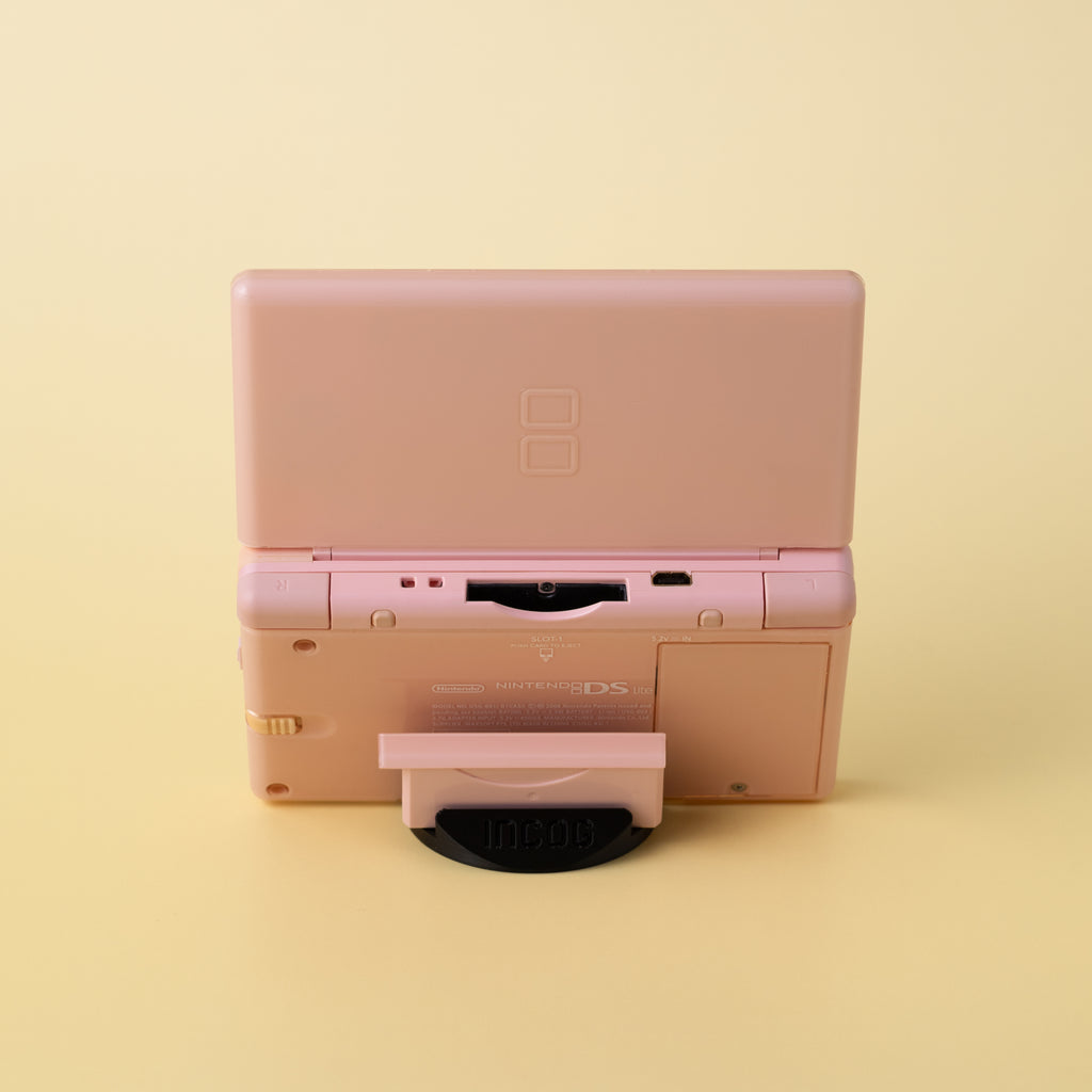 Close-up of the low-profile INCOG stand supporting a Nintendo DS Lite, showing the 'hidden' design.
