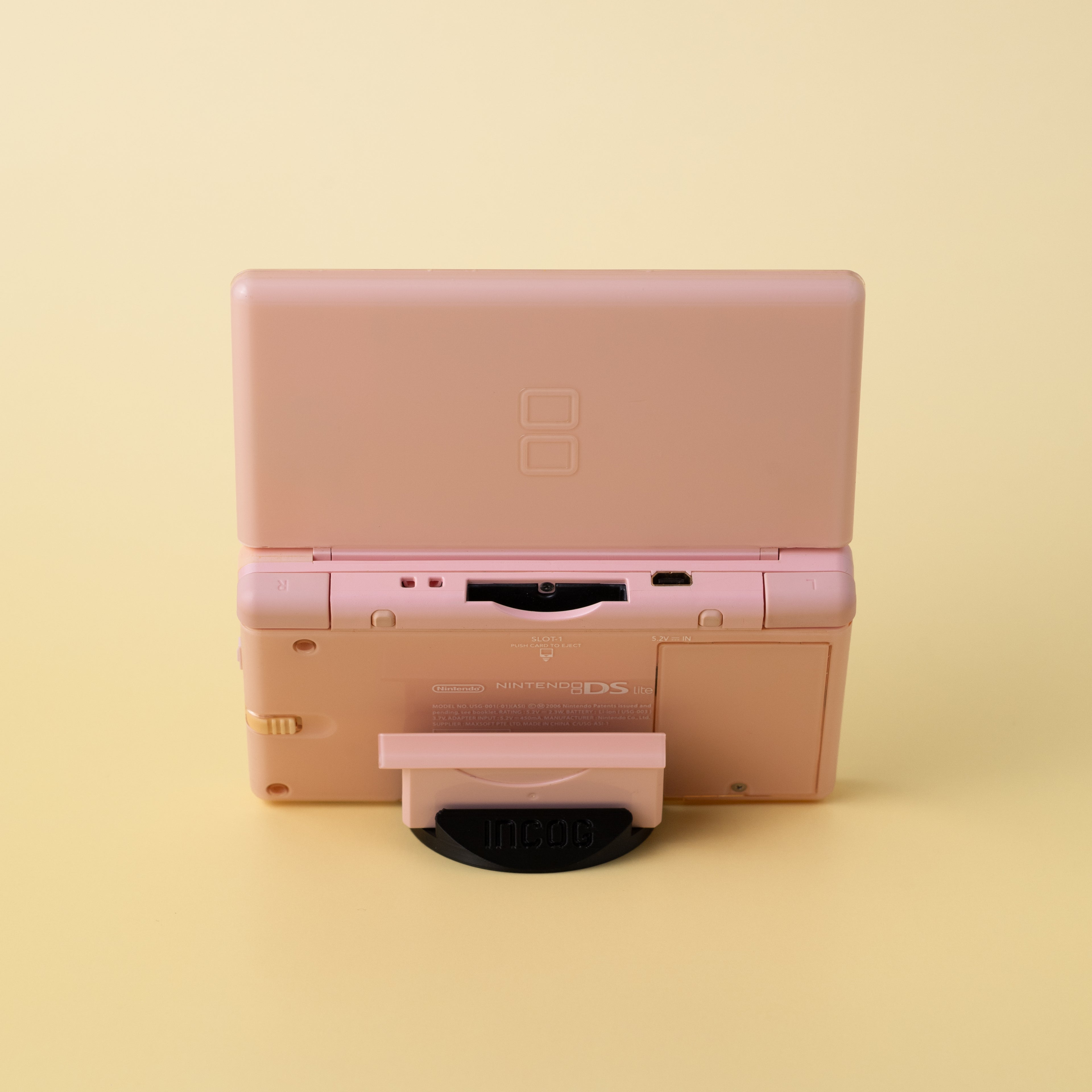 Close-up of the low-profile INCOG stand supporting a Nintendo DS Lite, showing the 'hidden' design.