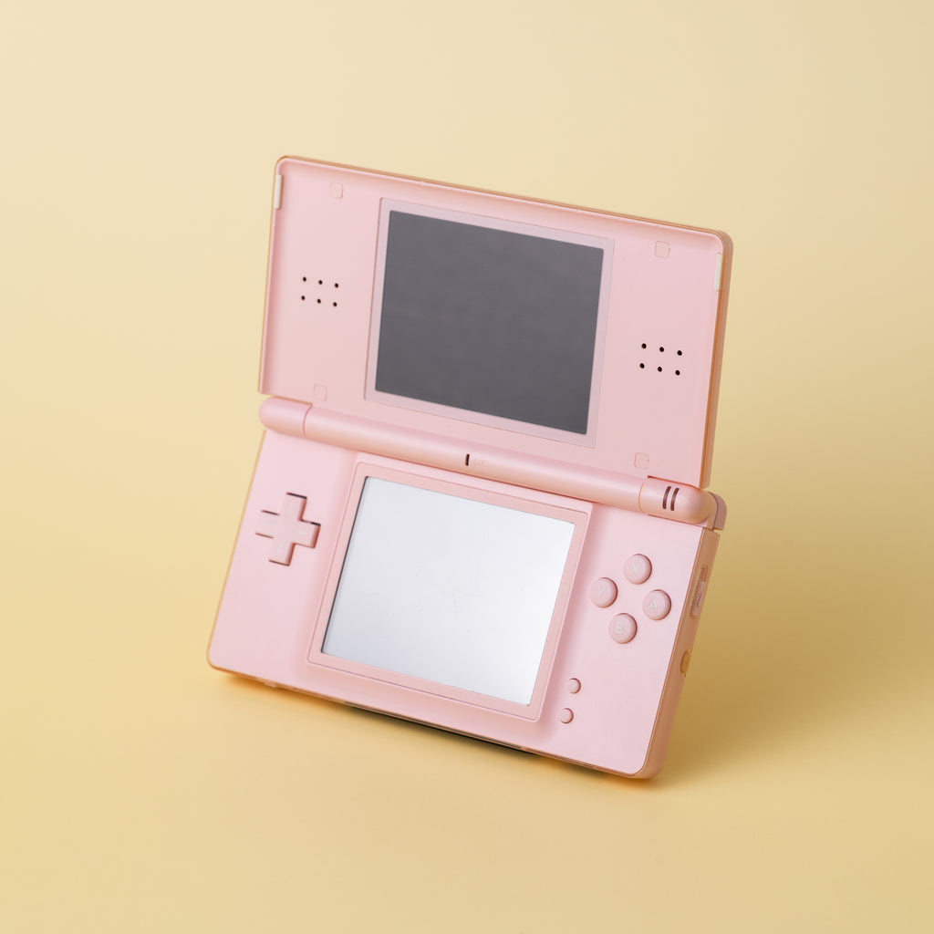 INCOG display stand showcasing a light pink Nintendo DS Lite on a pale yellow background at a 45-degree angle.