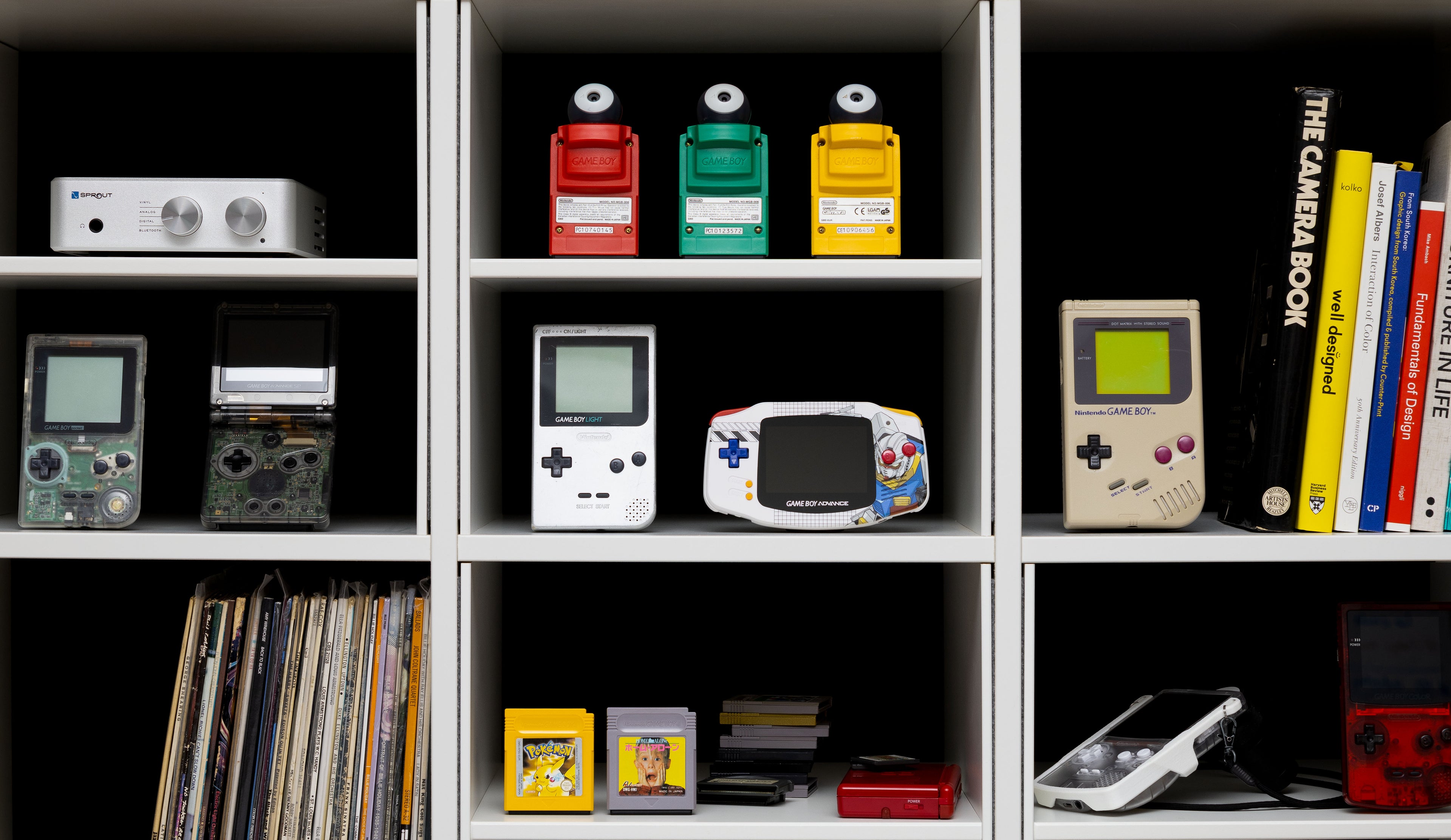 Collection of vintage electronic devices and books on a shelf
