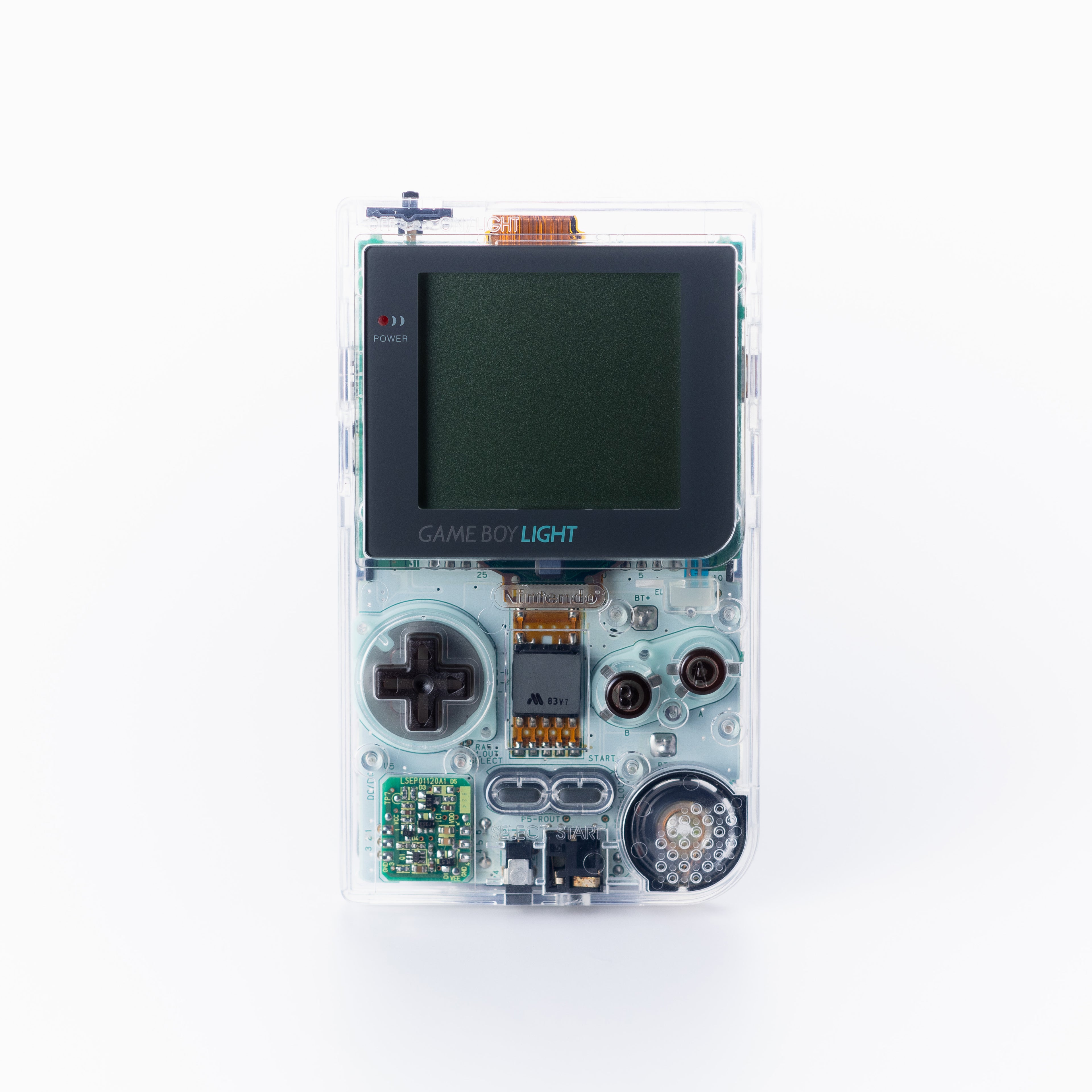 A transparent Game Boy light, showing the internal circuit board, set against a plain off white background.