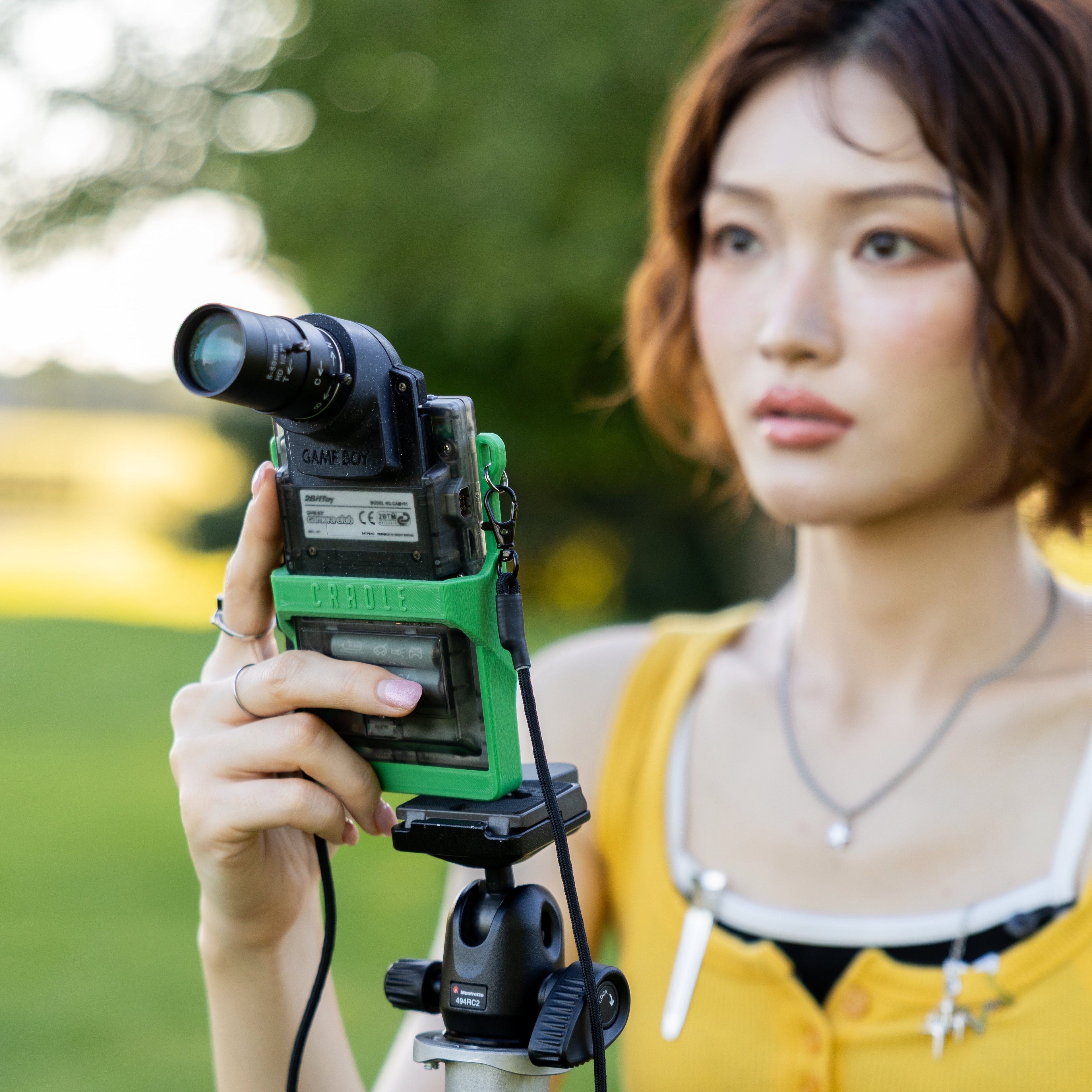 Back view of a woman using a 3D-printed Game Boy Pocket mount to take a photo.